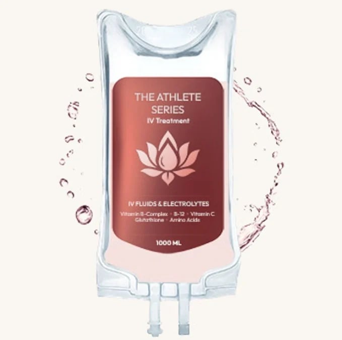 Medical IV bag labeled The Athlete Series IV Treatment with lotus logo, containing fluids and electrolytes, surrounded by water splashes